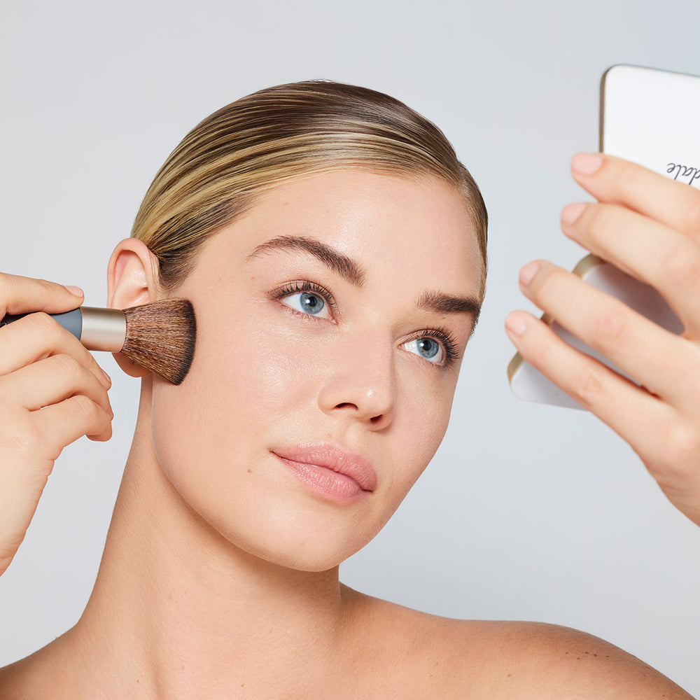 ZEITWUNDER - jane iredale - Ein Model trägt sich mit dem Handi Brush das Pure Pressed Base Mineral Puder im Gesicht auf